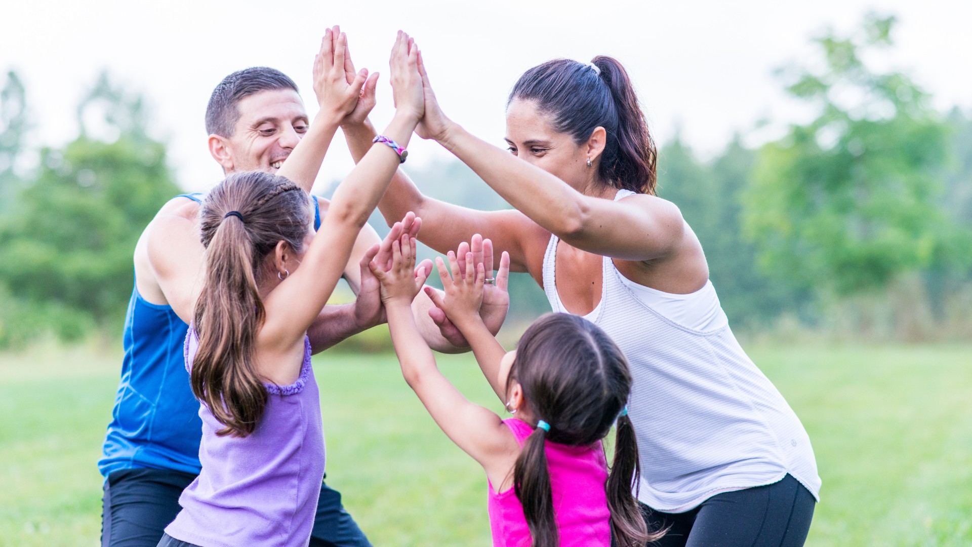 Image of 2 adults and 2 children high fiving each other