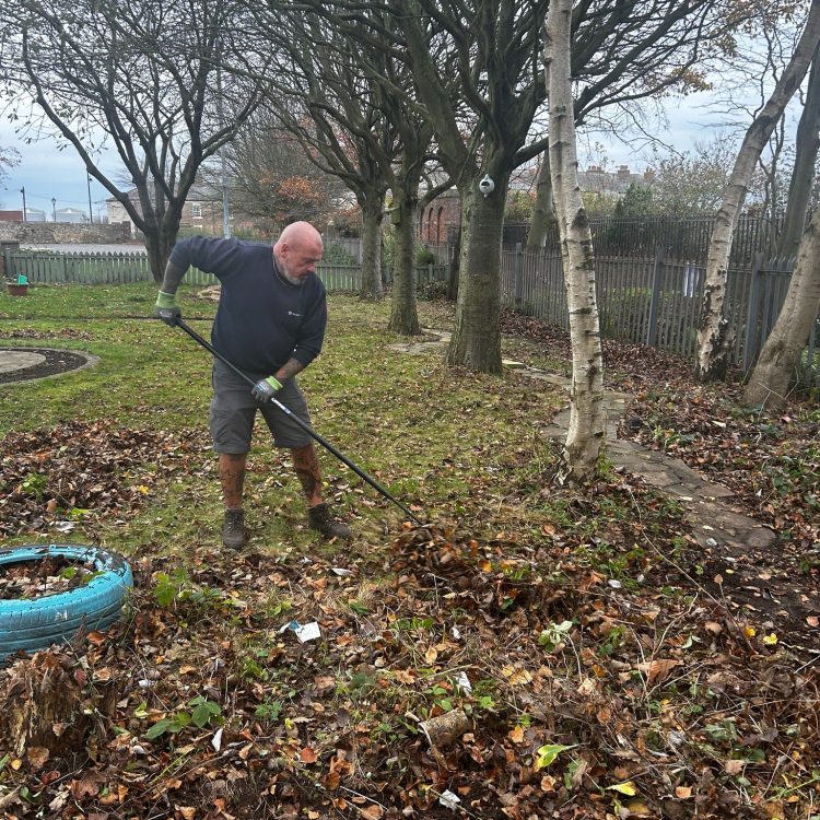 One workman from AESC clearing leaves on the path