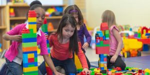 Children and toddlers playing with building blocks.